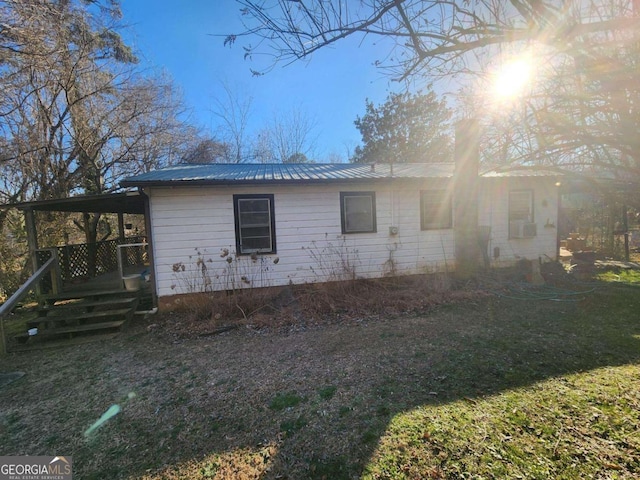 view of home's exterior with metal roof, a carport, and a yard