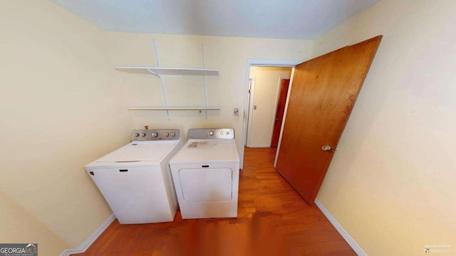 washroom featuring laundry area, light wood-style flooring, baseboards, and separate washer and dryer