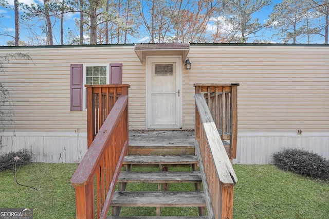 view of exterior entry with a yard
