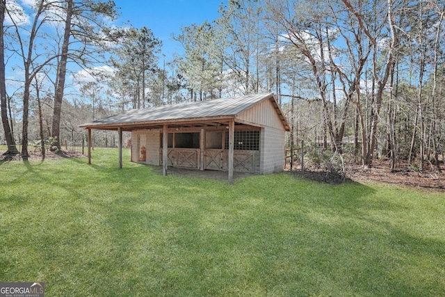 exterior space with metal roof, a yard, an outdoor structure, and an exterior structure