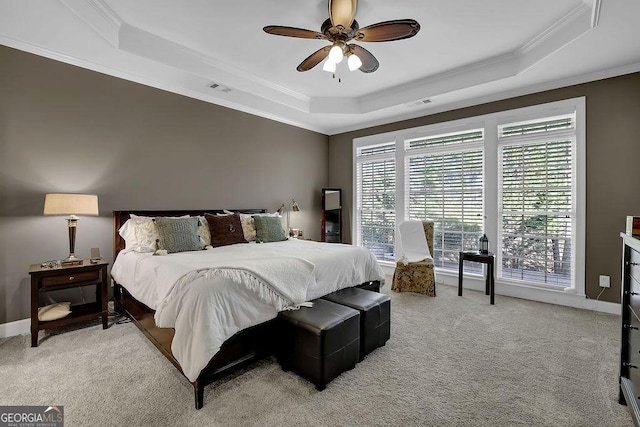 bedroom featuring light carpet, a raised ceiling, visible vents, and crown molding