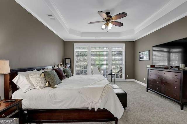 bedroom with ornamental molding, visible vents, a raised ceiling, and light colored carpet