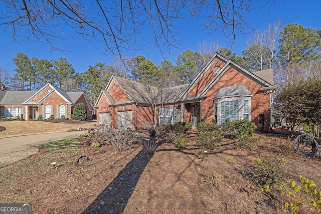 view of front of property with a garage, driveway, and brick siding