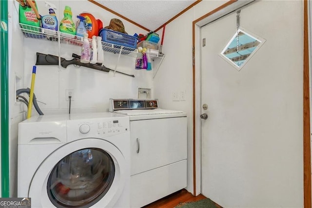 clothes washing area featuring laundry area, washer and clothes dryer, dark wood finished floors, and crown molding