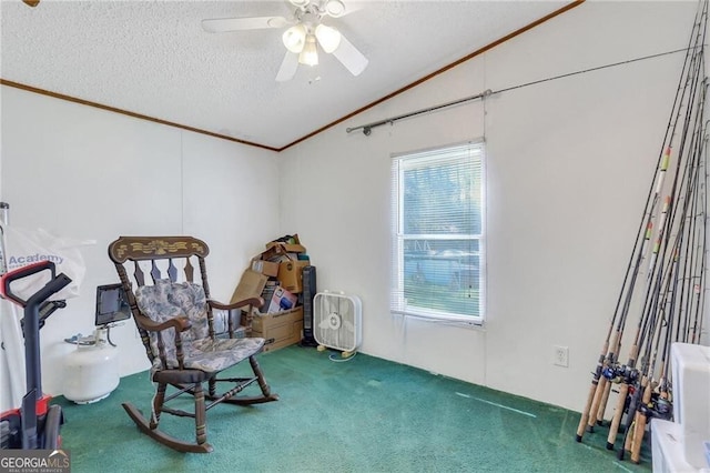 sitting room featuring lofted ceiling, ceiling fan, a textured ceiling, carpet, and crown molding