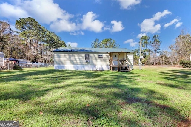 back of property with metal roof and a yard