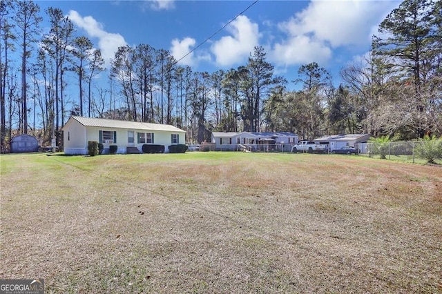 exterior space with fence and a front lawn