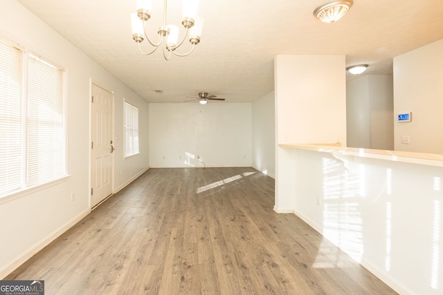 entryway featuring light wood-type flooring, baseboards, and ceiling fan with notable chandelier