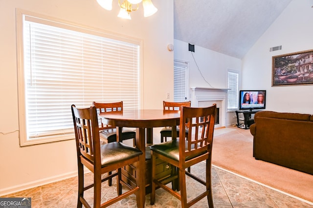 dining room with lofted ceiling, light colored carpet, a fireplace, visible vents, and baseboards