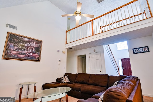 living area with baseboards, a high ceiling, visible vents, and a ceiling fan