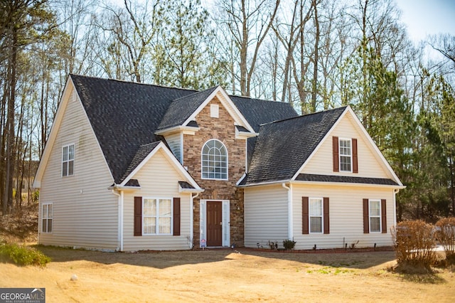 traditional-style house featuring stone siding and roof with shingles