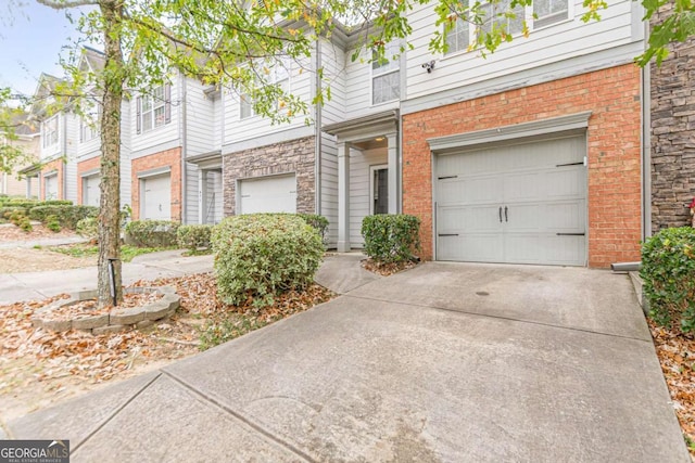 view of property with concrete driveway, brick siding, and an attached garage