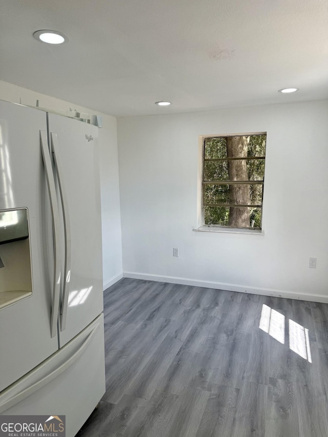 kitchen with baseboards, white refrigerator with ice dispenser, wood finished floors, and recessed lighting