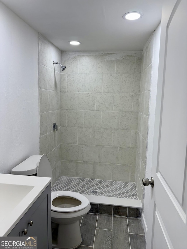 bathroom with toilet, a stall shower, recessed lighting, and vanity