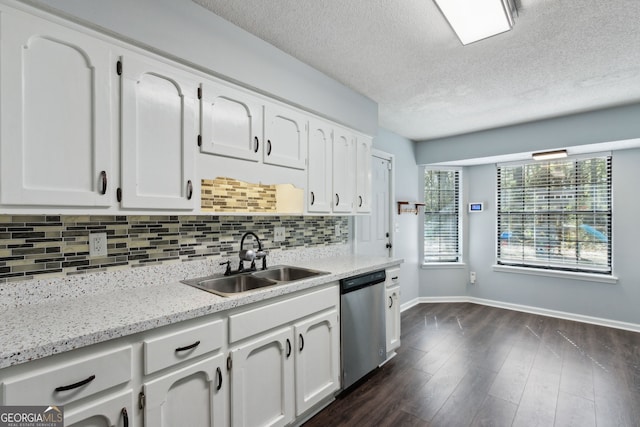 kitchen featuring dark wood-style floors, tasteful backsplash, stainless steel dishwasher, white cabinets, and a sink