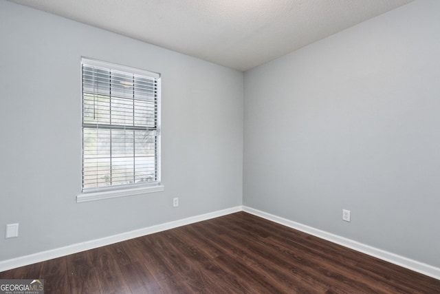 unfurnished room featuring dark wood finished floors and baseboards