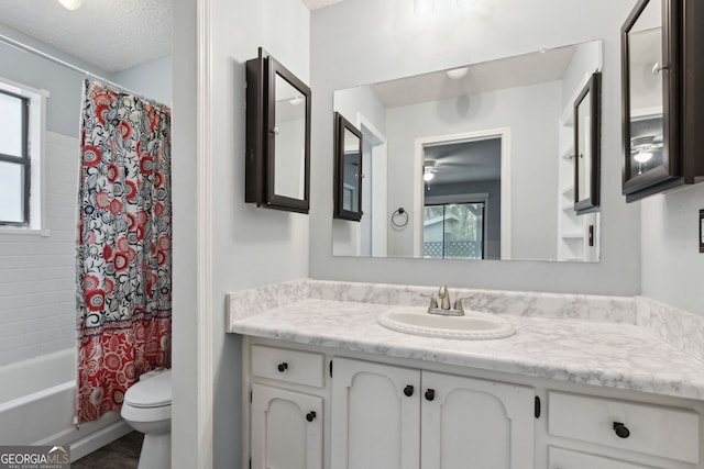 full bath featuring toilet, a textured ceiling, a wealth of natural light, and vanity