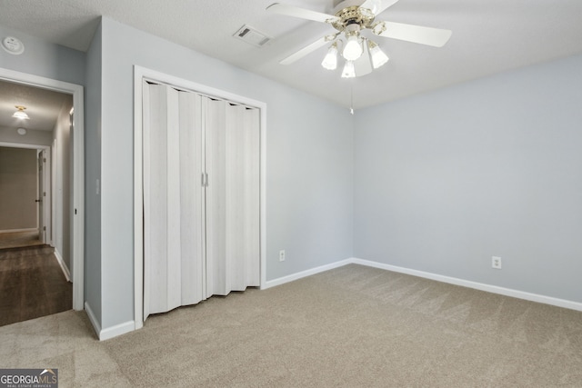 unfurnished bedroom with light carpet, baseboards, visible vents, a ceiling fan, and a closet