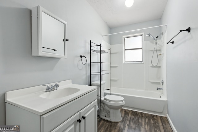 full bath with toilet,  shower combination, wood finished floors, and vanity