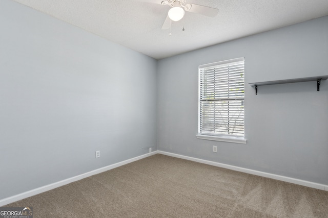 carpeted empty room with ceiling fan, baseboards, and a textured ceiling