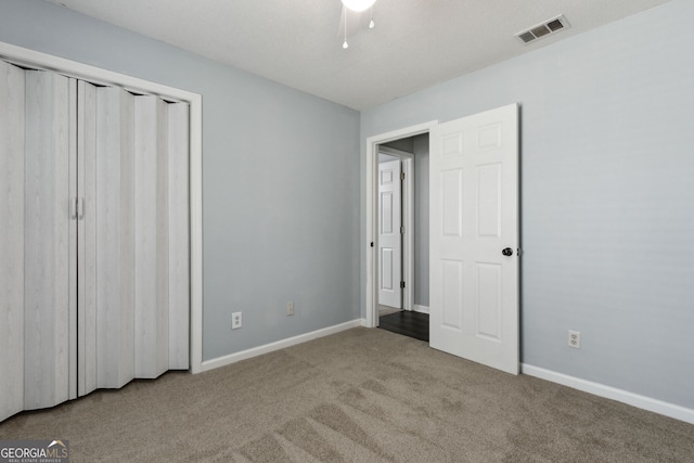 unfurnished bedroom featuring carpet, a closet, visible vents, and baseboards