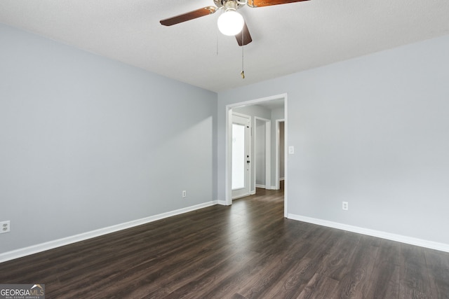 spare room with dark wood-style flooring, ceiling fan, and baseboards