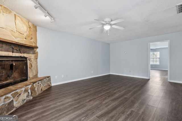 unfurnished living room featuring baseboards, visible vents, a ceiling fan, dark wood-style floors, and a fireplace