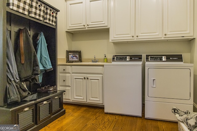 laundry area featuring a sink, cabinet space, dark wood-style flooring, and independent washer and dryer