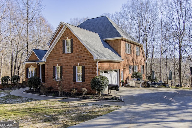 view of front of house with a garage, driveway, and brick siding