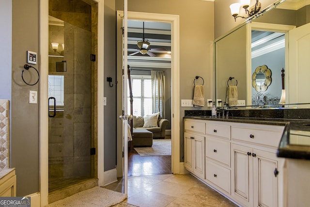 bathroom featuring a stall shower, ceiling fan, vanity, and baseboards