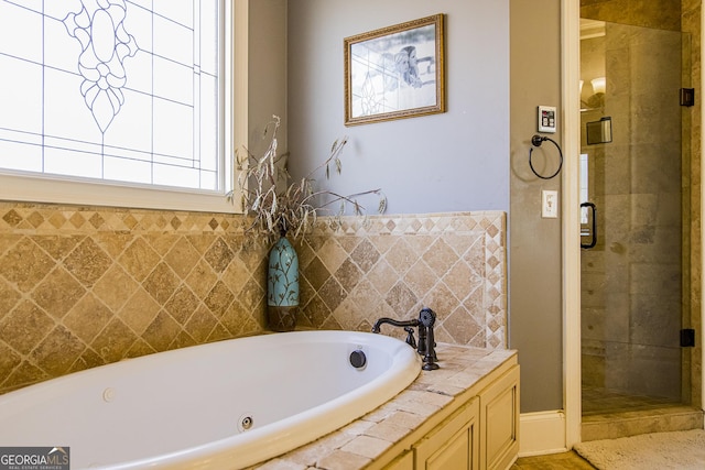 full bath featuring a garden tub and a shower stall