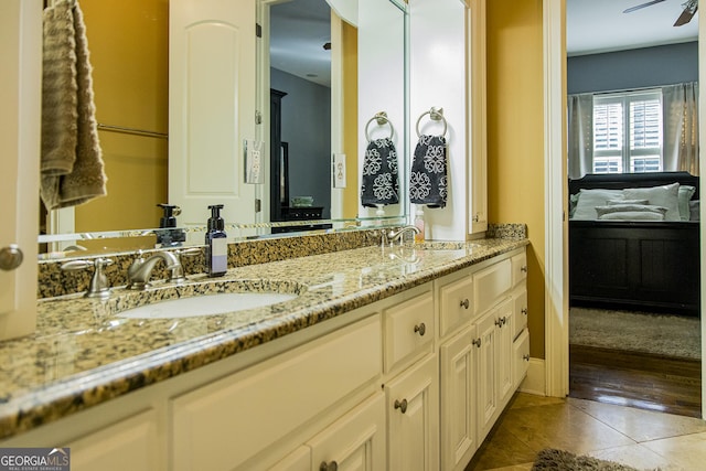 ensuite bathroom with a sink, double vanity, ensuite bath, and tile patterned floors