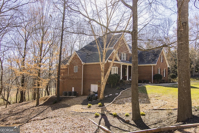 view of home's exterior with central AC unit and brick siding