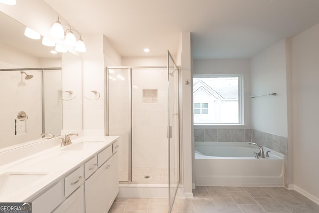 bathroom with a stall shower, a garden tub, a sink, and double vanity