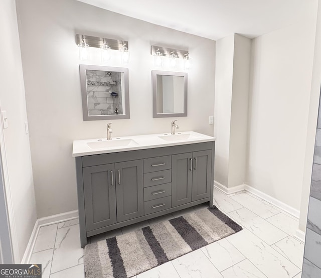 bathroom with marble finish floor, baseboards, and a sink