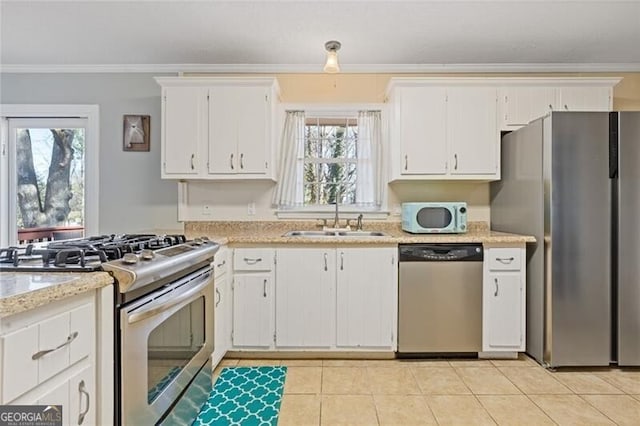 kitchen with light stone counters, a sink, white cabinetry, ornamental molding, and appliances with stainless steel finishes