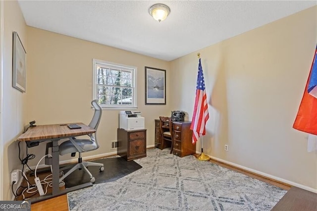 home office featuring a textured ceiling and baseboards