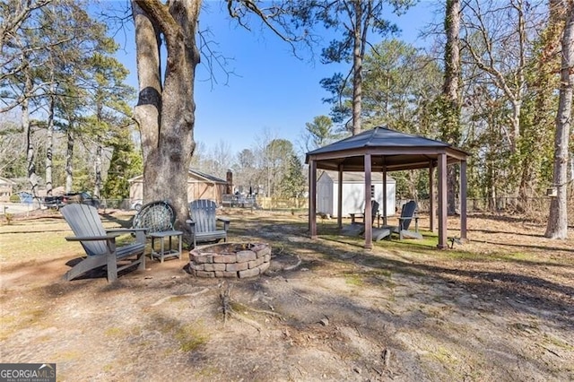 view of yard with a gazebo, an outdoor fire pit, and fence