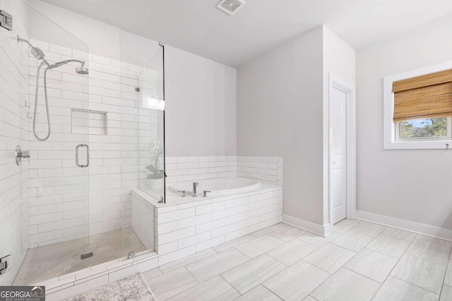 full bathroom featuring a stall shower, visible vents, a garden tub, and baseboards