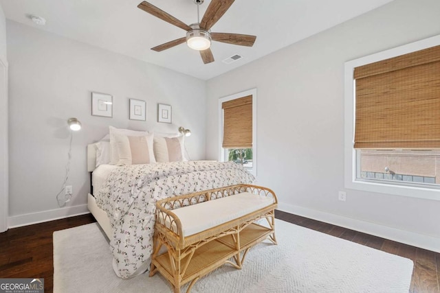 bedroom with a ceiling fan, baseboards, visible vents, and dark wood-type flooring