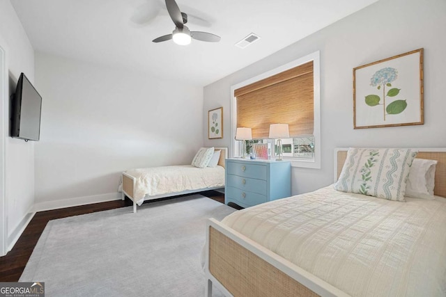 bedroom featuring ceiling fan, dark wood finished floors, visible vents, and baseboards