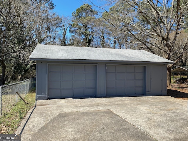 detached garage featuring fence