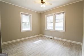 unfurnished room featuring crown molding, light wood-style flooring, baseboards, and ceiling fan