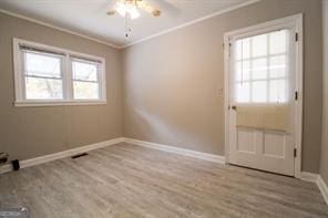 unfurnished room with baseboards, light wood-type flooring, and crown molding