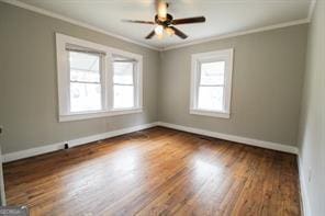 empty room with ornamental molding and plenty of natural light