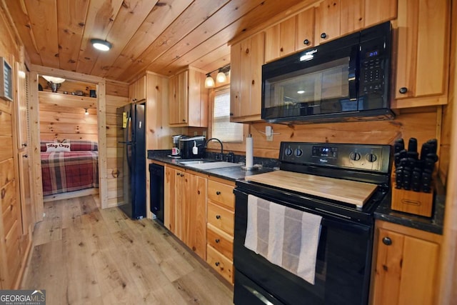 kitchen featuring wooden ceiling, wooden walls, a sink, black appliances, and dark countertops