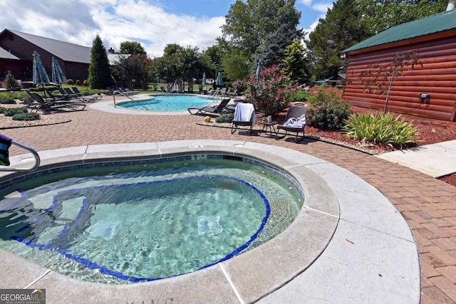 community pool with a community hot tub and a patio