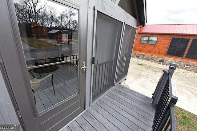 view of exterior entry with stone siding and metal roof