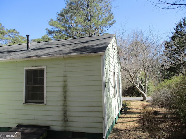 view of property exterior with roof with shingles