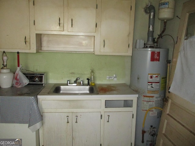 kitchen featuring water heater, light countertops, and a sink